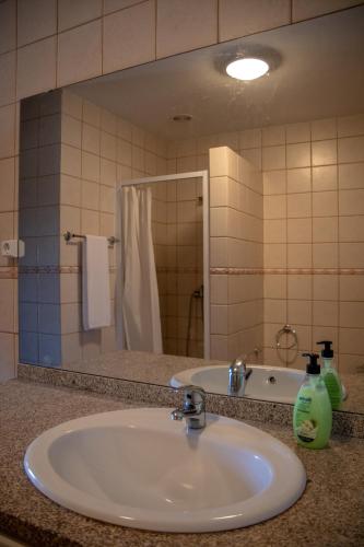 a bathroom counter with a sink and a mirror at Casa da Anta Grande in Celorico de Basto