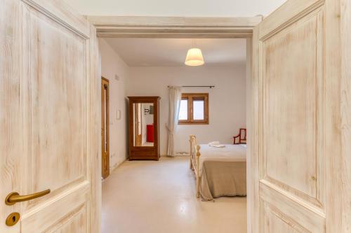 a bedroom with a bed and a room with a door at Masseria Scafazzi - Salento in Presicce