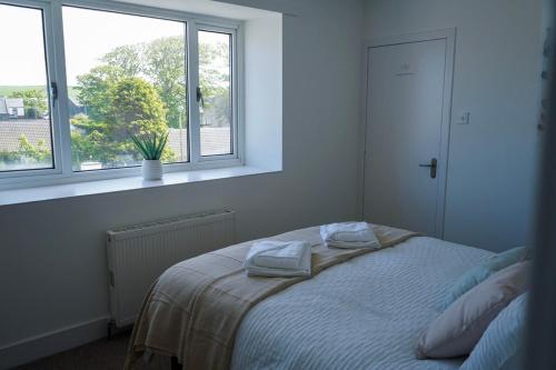a bedroom with a bed with two towels on it at Park House - 3 bedroom in Portsoy