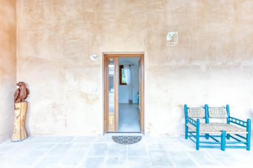 a building with a blue bench next to a door at Masseria Scafazzi - Salento in Presicce
