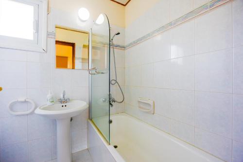 a bathroom with a shower and a sink and a bath tub at Villa Aristotelis in Argaka