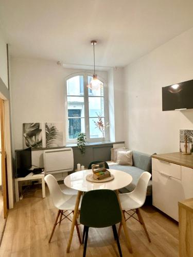 une cuisine et un salon avec une table et des chaises dans l'établissement Au Coeur de Nantes - idealement situé Studio tout confort avec chambre separée, à Nantes