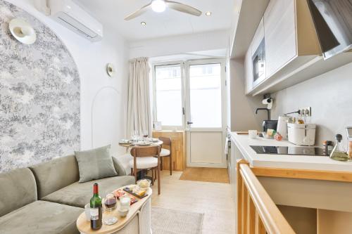 un salon avec un canapé et une cuisine dans l'établissement New! Le Vénitien, Parisian Getaway, Sacré-Cœur, à Paris