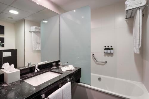 a white bathroom with a sink and a shower at Catalonia Málaga in Málaga