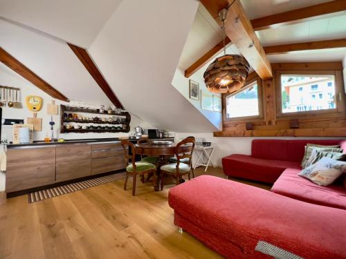 a living room with a red couch and a table at La Casa Del Sole in Terzolas