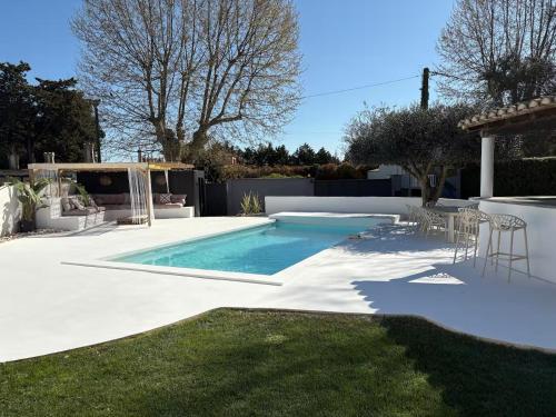 エマルグにあるMaison de standing proche de la merの家の裏庭にあるプール