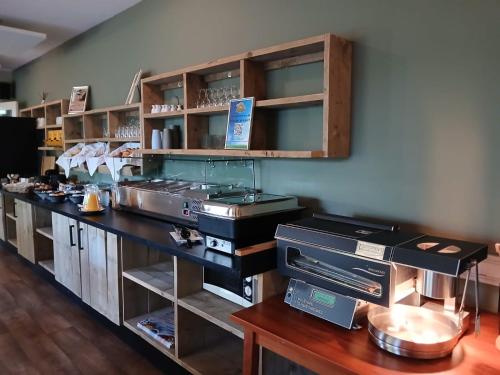 a kitchen with a counter with shelves and a counter top at Drouwenerzand Hotel in Drouwen