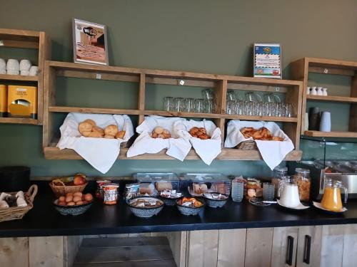 a counter with bread and other food items on it at Drouwenerzand Hotel in Drouwen
