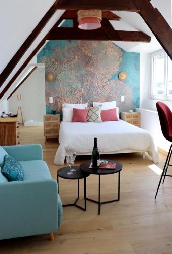 une chambre avec un lit, un canapé et une table dans l'établissement La Bulle d'Etel, Chambres & Spa, à Étel