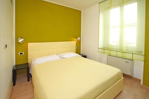 a bedroom with a white bed and a green wall at Hotel Roma in Trieste