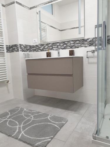 a white bathroom with a sink and a mirror at Casa Molly in Follonica