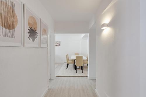 a hallway with a dining room with a table at Bright & Family Flat in Paço de Arcos by HostWise in Lisbon