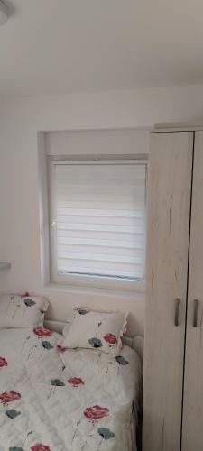 a bedroom with a bed with a window at Mila in Soko Banja