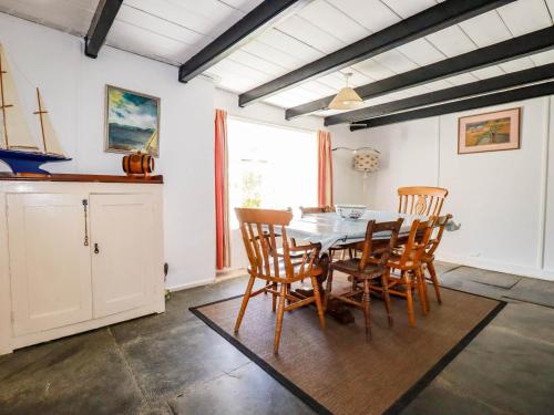 a dining room with a table and chairs at Polcreek Farmhouse in Veryan