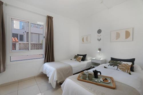 a hotel room with two beds and a tray of food at Serene Terrace And Pool in Playa de las Americas
