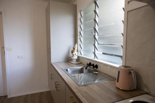 a kitchen with a sink and a window at The Little Gem in Clermont