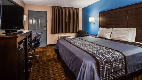 a hotel room with a bed and a flat screen tv at SureStay Hotel by Best Western Terrell in Terrell