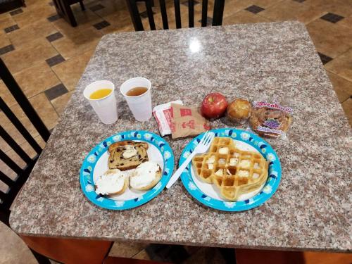 a table with two plates of food and two cups of coffee at SureStay Hotel by Best Western Terrell in Terrell