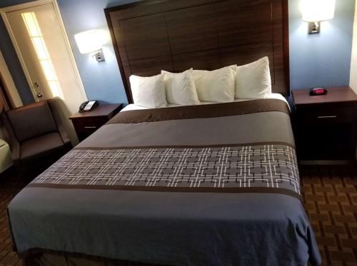 a hotel room with a large bed with white pillows at SureStay Hotel by Best Western Terrell in Terrell