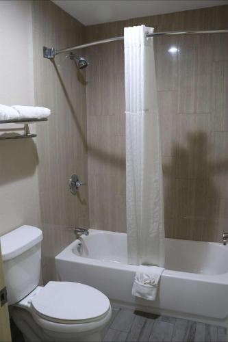 a bathroom with a toilet and a tub and a sink at SureStay Hotel by Best Western Terrell in Terrell