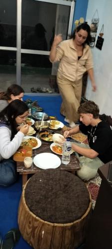 a group of people sitting around a table with food at Nirvana Heights Kasar Devi in Hawālbāgh