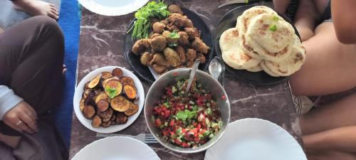 a group of people sitting on a table with food at Nirvana Heights Kasar Devi in Hawālbāgh