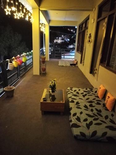 a room with a bed and a table on a balcony at Nirvana Heights Kasar Devi in Hawālbāgh
