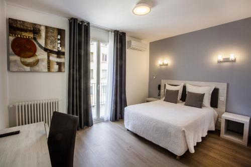 a bedroom with a white bed and a window at Hôtel Sampiero Corso in Corte
