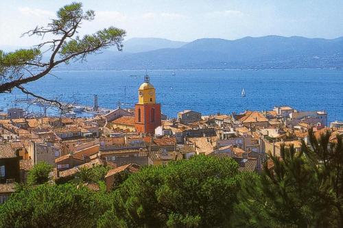 a city with a clock tower and the water at 2-room holiday flat with sea view in Residence du Bailli, Rayol-Canadel-sur-Mer in Rayol-Canadel-sur-Mer