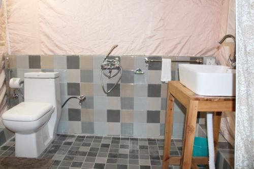 a bathroom with a toilet and a sink at CampKelang Bir Luxury Tents in Bir Billing in Bīr