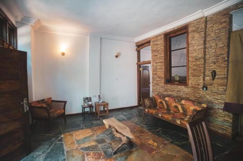 a living room with a couch and a brick wall at The Cave Suite in Obosomasi