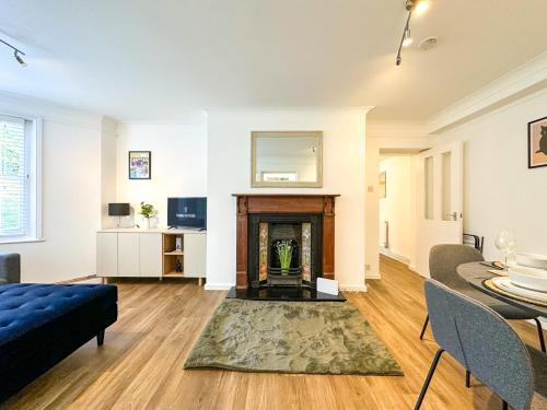 a living room with a fireplace and a table at Folkestone Oasis - Central 2 Bedroom Apartment - Pets Welcome! in Folkestone