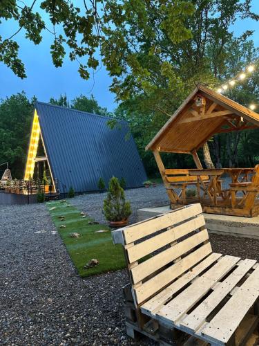 a pavilion and a bench in front of a building at Wood Side in Tʼerjola