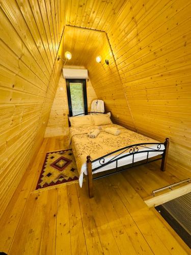 a bedroom with a bed in a wooden room at Wood Side in Tʼerjola