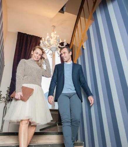 a bride and groom walking down the stairs at their wedding at Hotel 1016 Olav Digre in Sarpsborg