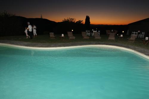 a group of people standing next to a swimming pool at Resort con vista nel Chianti Rufina in Londa