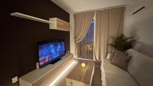 Una sala de estar con un sofá y una ventana grande. en Apartamento en Canet De Berenguer Playa - Valencia, en Valencia