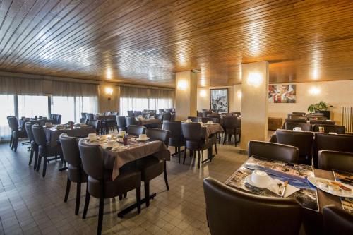 une salle à manger avec des tables et des chaises dans un restaurant dans l'établissement Hôtel Sampiero Corso, à Corte