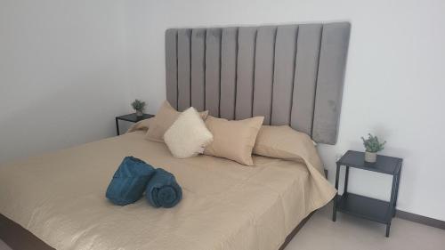 Un dormitorio con una cama con una bolsa azul encima. en Casa cerca todo en Zapopan !, en Guadalajara