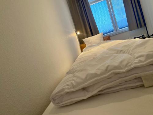 an unmade bed in a room with a window at Ferienwohnung Nordwind - Haus Seeschwalbe in Wangerland