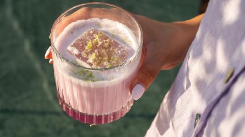 a person holding a glass of a pink drink at Mitsis N'U Piraeus Port in Piraeus