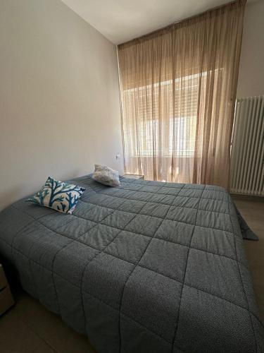 a bedroom with a large bed with a large window at Casa Molly in Follonica