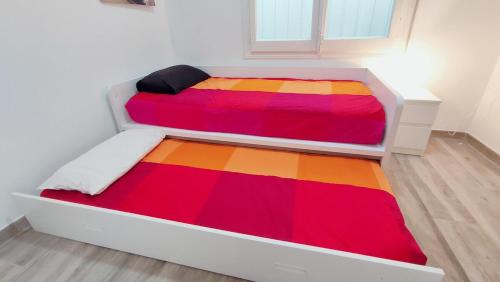 a bedroom with two beds with a colorful blanket at Enjoy this apartment, with two bedrooms in Sant Adria de Besos