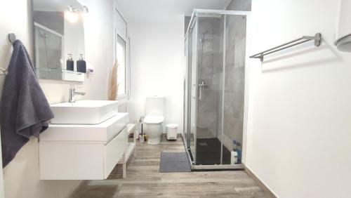 a white bathroom with a sink and a shower at Enjoy this apartment, with two bedrooms in Sant Adria de Besos