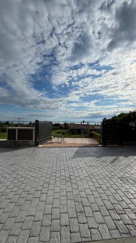 a brick patio with a cloudy sky in the background at Vita sul Garda in Bardolino