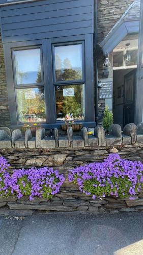 a bunch of purple flowers in front of a building at Autumn Leaves Guest House in Windermere