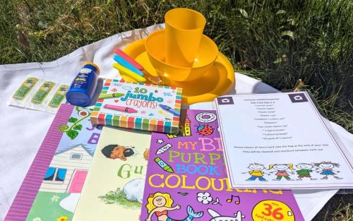 a picnic blanket with books and a pump bookocal at Unique & Rural Child Friendly Annexe with Large Gardens, Games & Tennis Court - Chichester Holiday Properties in Chichester