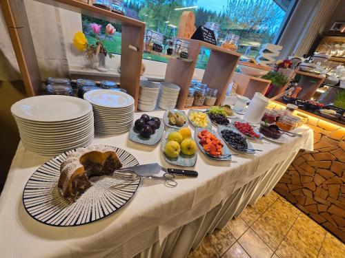 a table with plates of food on it at Hotel Gästehaus Neubauer in Kaltenberg