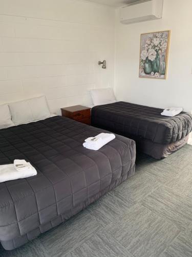 two beds sitting in a room with at Brooklyne Motel Sanson in Sanson