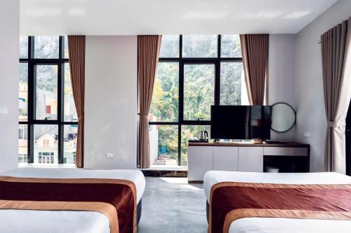 a hotel room with two beds and a flat screen tv at Cat Ba Viet Hoa Hotel & Residence - Pool & Bar in Cat Ba